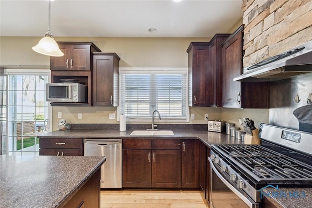 4218 Herdmans Cir, Maumee, OH 43537 - kitchen featuring stainless steel appliances, a sink, dark countertops, dark brown cabinetry, and pendant lighting