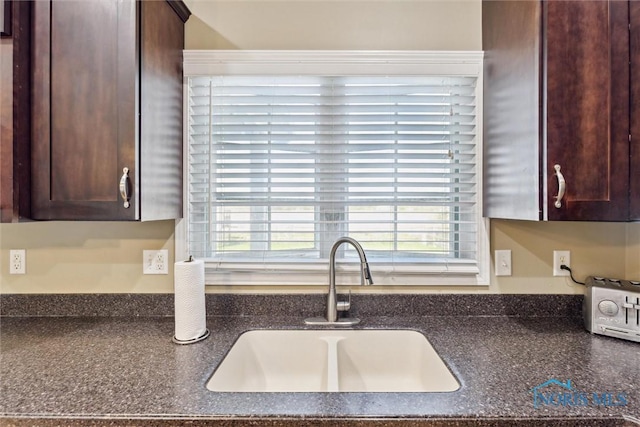 kitchen with a sink and dark brown cabinetry