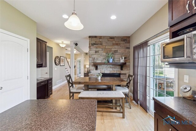 dining area featuring stairway, baseboards, visible vents, and light wood finished floors