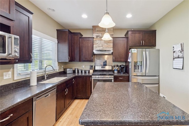 4218 Herdmans Cir, Maumee, OH 43537 - kitchen with stainless steel appliances, a sink, ventilation hood, light wood finished floors, and a center island
