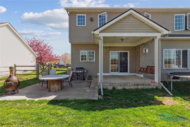 back of house featuring fence, a yard, and a patio area