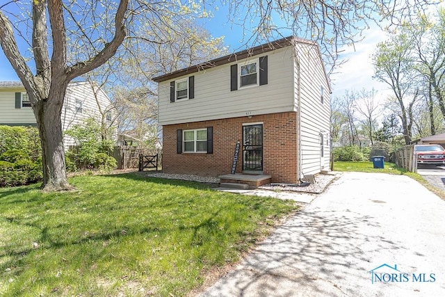 853 Circleview Dr, Toledo, OH 43615 - colonial-style house with brick siding, fence, driveway, and a front yard