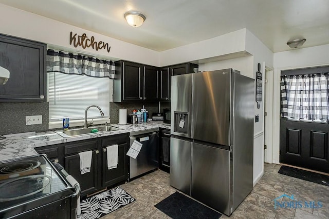 853 Circleview Dr, Toledo, OH 43615 - kitchen with decorative backsplash, dark cabinets, a sink, stone finish flooring, and stainless steel appliances