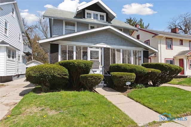 2000 Oakwood Ave, Toledo, OH 43607 - american foursquare style home featuring a shingled roof and a front lawn