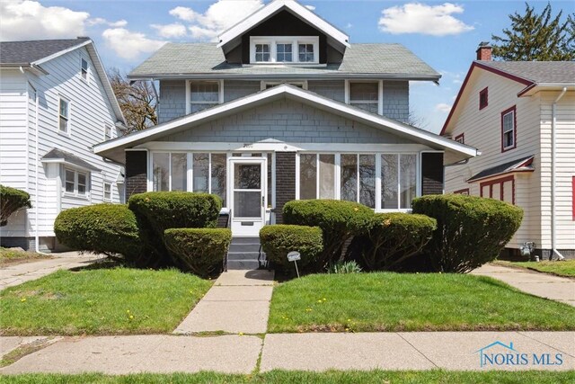 2000 Oakwood Ave, Toledo, OH 43607 - traditional style home with a sunroom, entry steps, and a front yard
