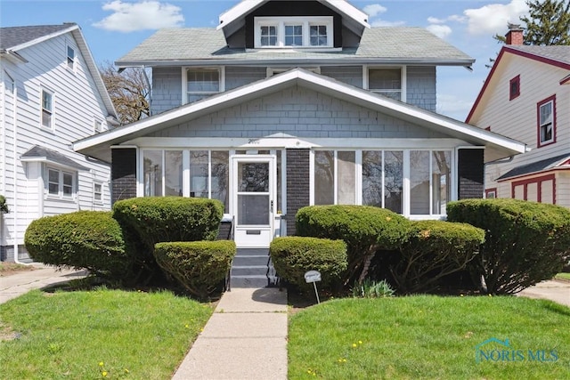 2000 Oakwood Ave, Toledo, OH 43607 - american foursquare style home with entry steps, a sunroom, and a front yard