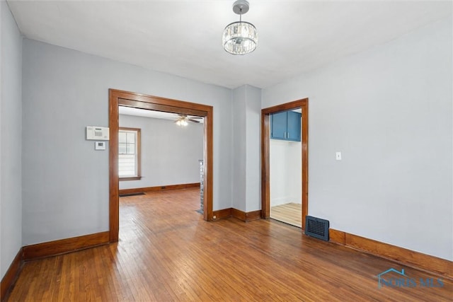 2000 Oakwood Ave, Toledo, OH 43607 - empty room with hardwood / wood-style flooring, baseboards, a chandelier, and visible vents