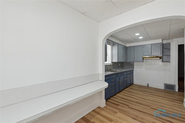 2000 Oakwood Ave, Toledo, OH 43607 - kitchen with a drop ceiling, visible vents, a sink, light wood-style floors, and blue cabinetry