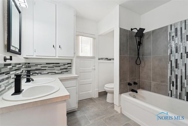 2000 Oakwood Ave, Toledo, OH 43607 - bathroom featuring a sink, double vanity, toilet, shower / bathtub combination, and backsplash