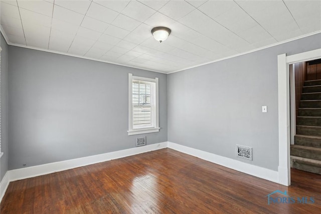 2000 Oakwood Ave, Toledo, OH 43607 - spare room featuring stairway, crown molding, baseboards, dark wood-style flooring, and visible vents