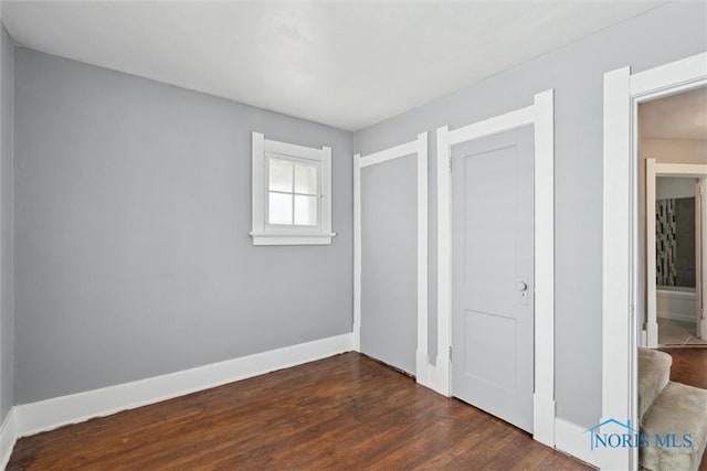 2000 Oakwood Ave, Toledo, OH 43607 - unfurnished bedroom with baseboards and dark wood-style floors