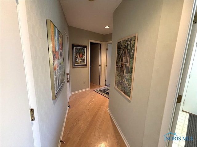 hallway featuring light wood-style floors, recessed lighting, and baseboards
