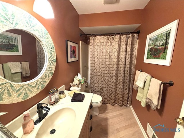 bathroom with wood finished floors, toilet, a shower with curtain, and vanity