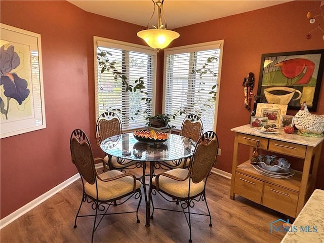 dining space featuring wood finished floors and baseboards
