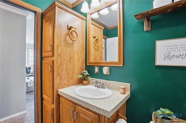 bathroom featuring ornamental molding, a notable chandelier, and vanity