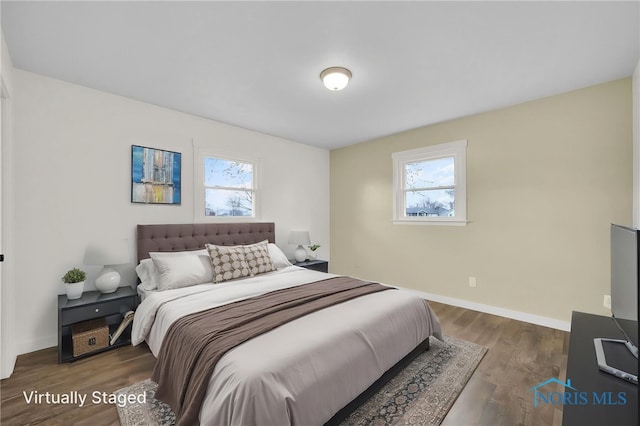 bedroom with baseboards, dark wood finished floors, and multiple windows