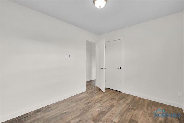 empty room with baseboards and wood finished floors