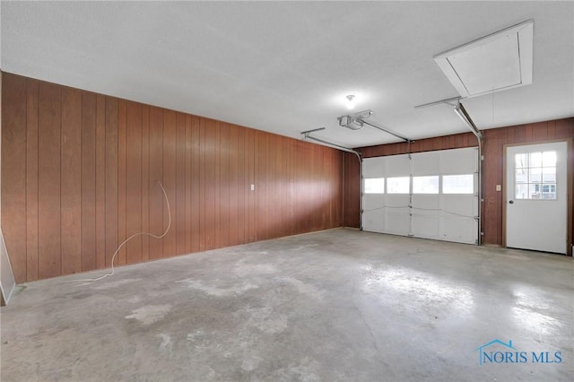 garage featuring wood walls and a garage door opener