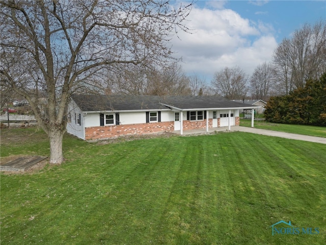 view of front of house featuring an attached garage, a front lawn, brick siding, and concrete driveway
