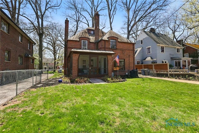 3122 Hopewell Pl, Toledo, OH 43606 - back of property with a chimney, brick siding, fence, a sunroom, and a lawn