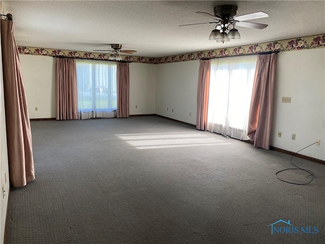 spare room featuring plenty of natural light, a ceiling fan, baseboards, and light carpet
