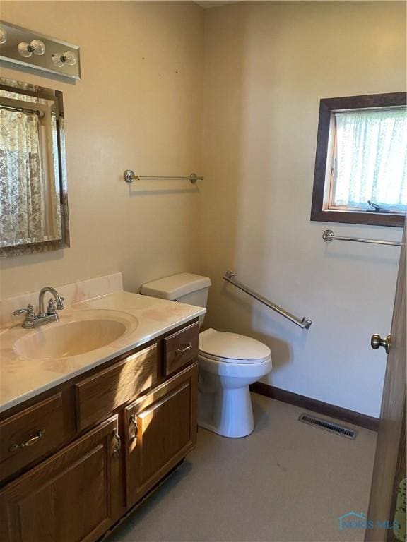 bathroom featuring visible vents, vanity, and toilet