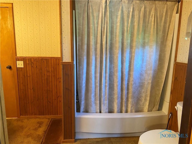 bathroom featuring wallpapered walls, a wainscoted wall, and toilet