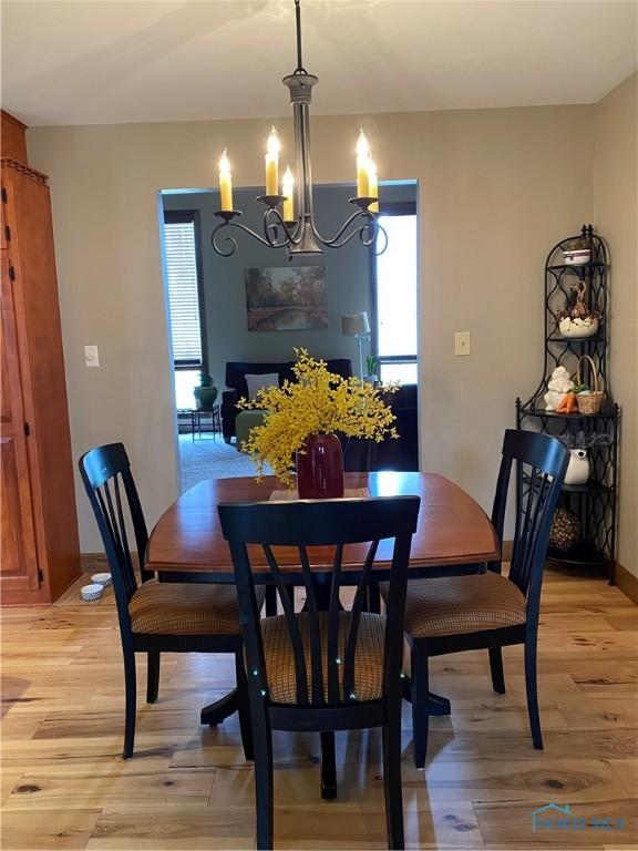 dining space featuring baseboards, an inviting chandelier, light wood-style floors, and plenty of natural light