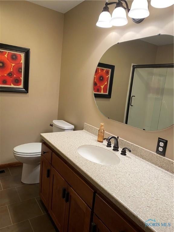 bathroom featuring toilet, tile patterned floors, a stall shower, vanity, and baseboards