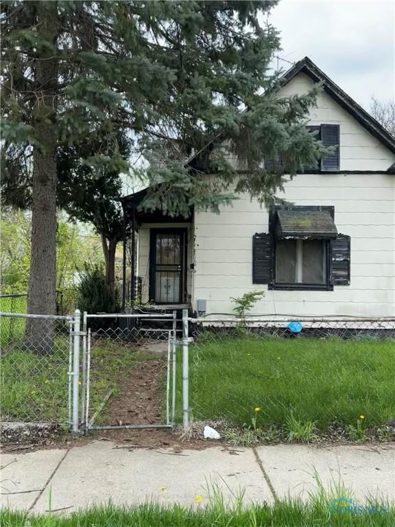 bungalow-style home featuring a gate, fence private yard, and a front lawn