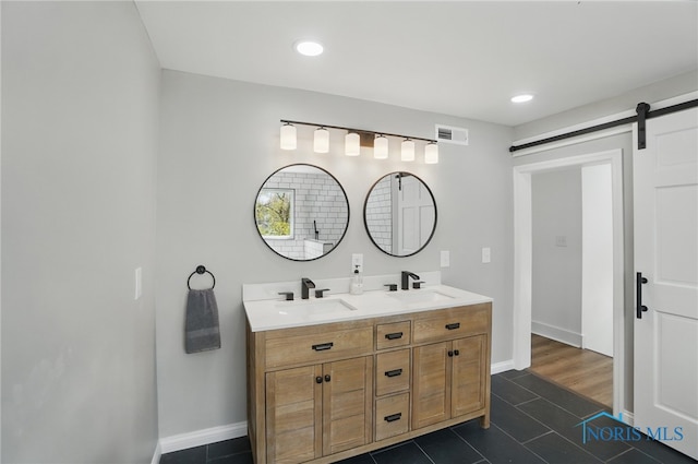 bathroom with tile patterned flooring, visible vents, a sink, and double vanity