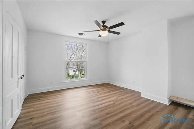 unfurnished bedroom featuring baseboards, a ceiling fan, and wood finished floors