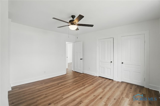 unfurnished bedroom with wood finished floors, a ceiling fan, and baseboards