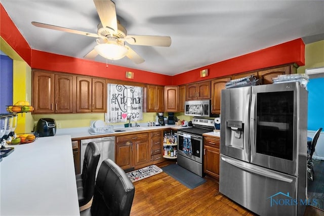 1705 Archwood Ln, Toledo, OH 43614 - kitchen with brown cabinetry, dark wood-type flooring, light countertops, a sink, and stainless steel appliances