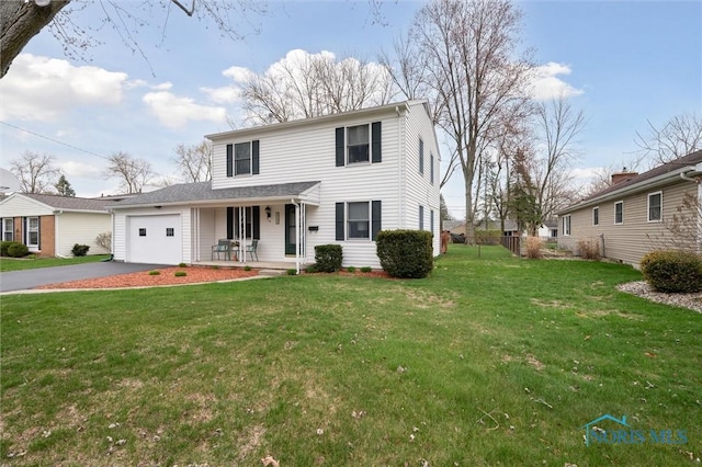 traditional home featuring an attached garage, aphalt driveway, covered porch, and a front yard