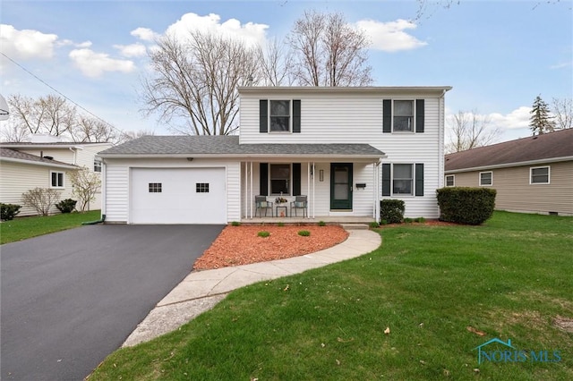 traditional-style house featuring a garage, a porch, a front yard, and aphalt driveway