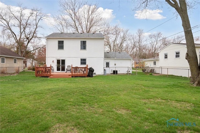rear view of house featuring a lawn, fence, and a deck