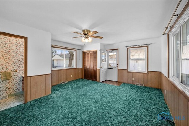 5148 Fern Dr, Toledo, OH 43613 - carpeted empty room featuring visible vents, a wainscoted wall, wooden walls, and a healthy amount of sunlight