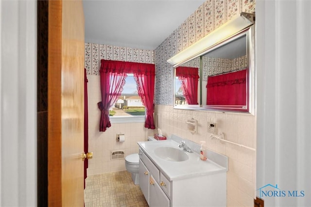 5148 Fern Dr, Toledo, OH 43613 - bathroom featuring vanity, tile patterned flooring, toilet, tile walls, and wallpapered walls