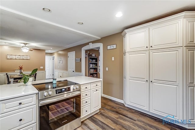 kitchen featuring light countertops, dark wood finished floors, ceiling fan, and stainless steel range with electric cooktop