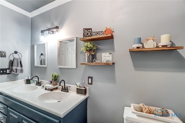 bathroom with crown molding, double vanity, a sink, and toilet
