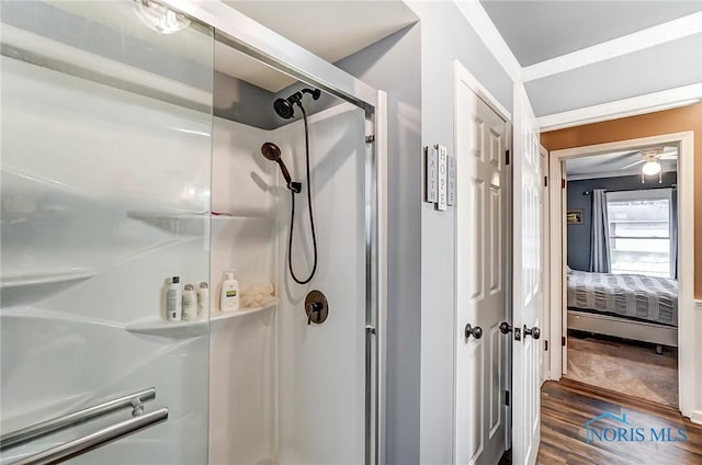 ensuite bathroom featuring wood finished floors, connected bathroom, and a stall shower