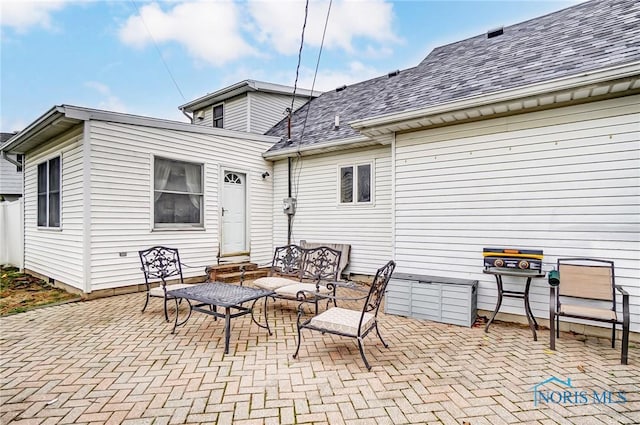 back of property featuring roof with shingles, a patio area, and entry steps