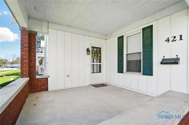 entrance to property with a porch and board and batten siding