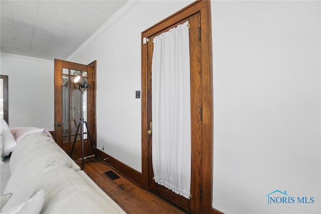 bedroom featuring baseboards, ornamental molding, and wood finished floors