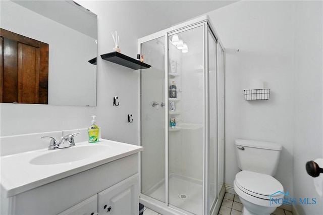 bathroom with toilet, vanity, tile patterned flooring, and a stall shower