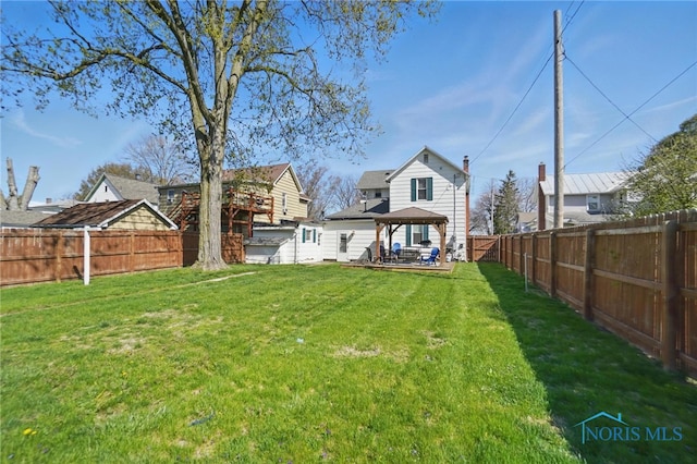 rear view of house featuring a lawn, a gazebo, and a fenced backyard