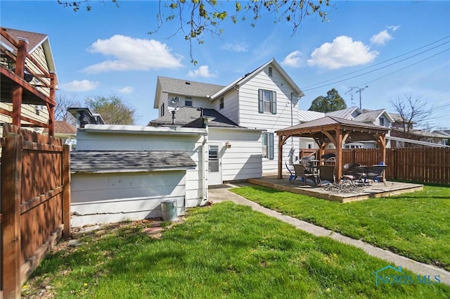 rear view of house featuring fence, a lawn, a gazebo, and a patio area
