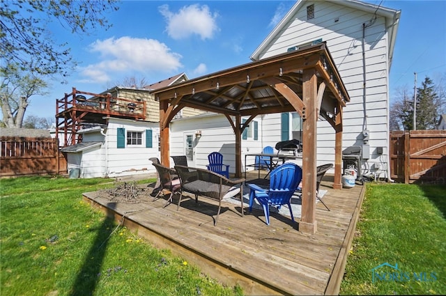 wooden deck featuring a gazebo, a lawn, outdoor dining area, and a fenced backyard