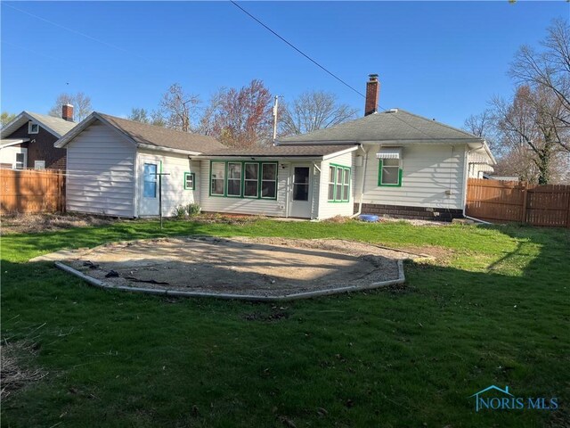 back of property with a lawn, a chimney, and fence